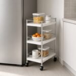 Slim rolling utility cart tucked into a narrow gap beside an apartment kitchen refrigerator